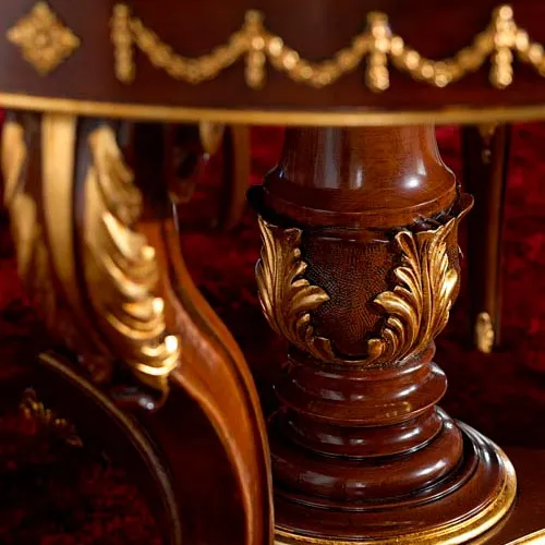 Carving of a handmade solid beech wood dining table decorated in gold leaf